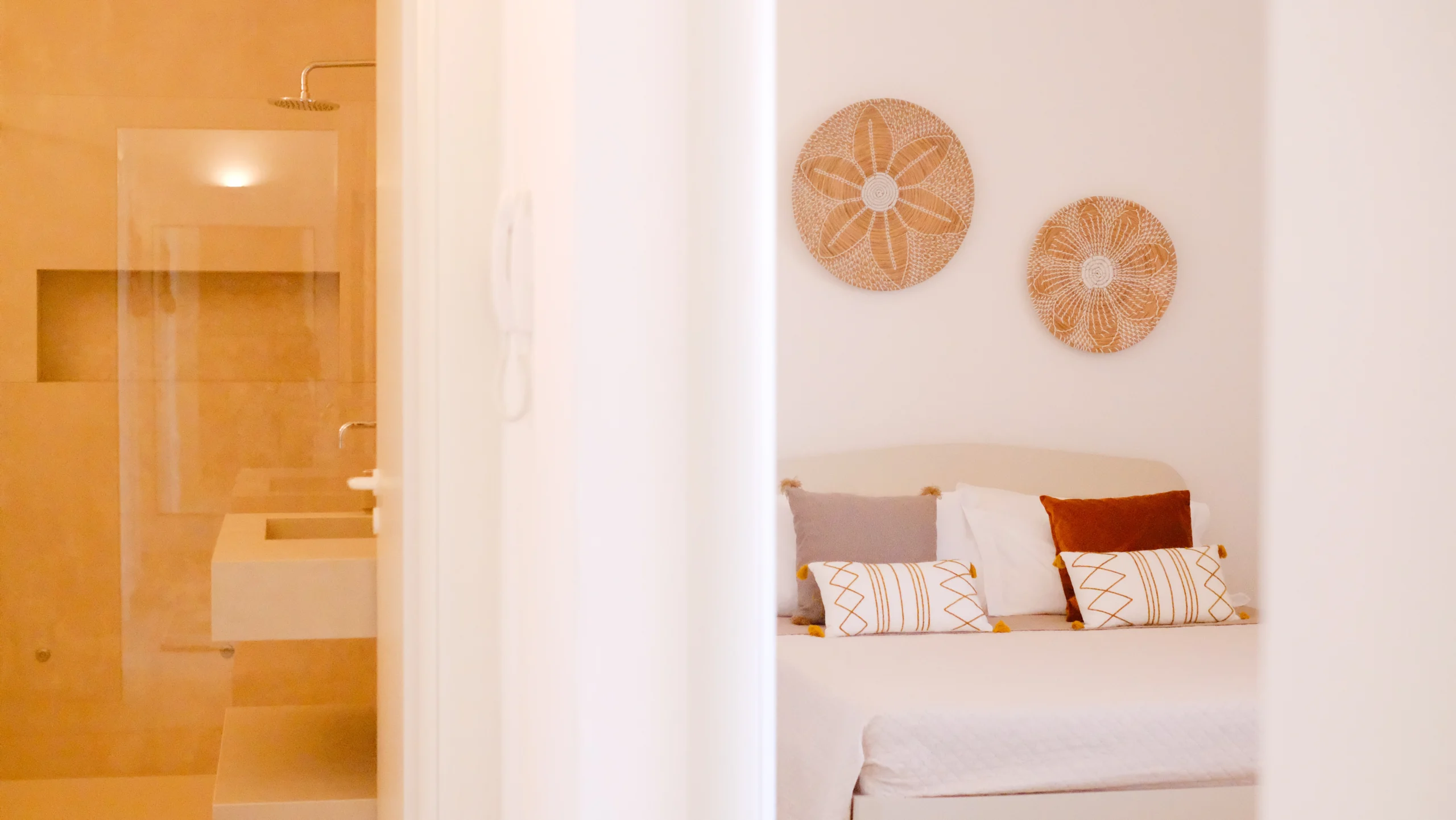 Bedroom and bathroom suite at Villa Leucade featuring walk-in shower, stone sink and designer bedroom decor.