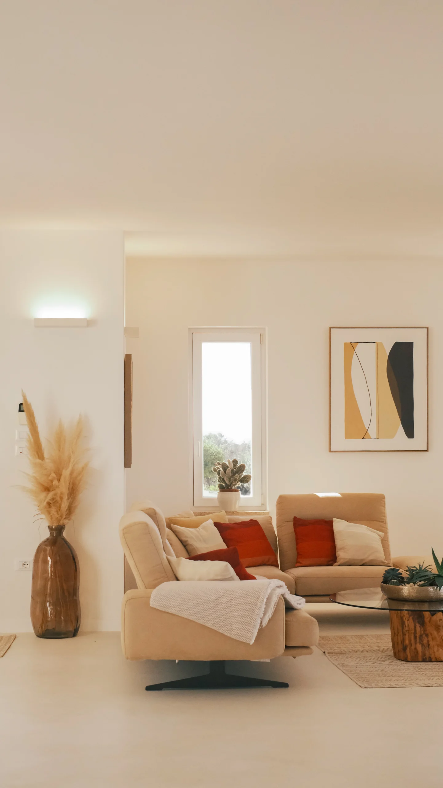 Luxury living room at Villa Leucade with beige sofas, modern artwork and natural light in a Puglia design villa.