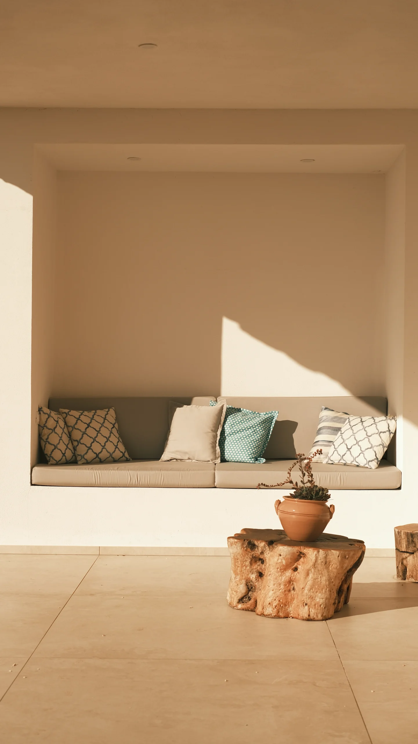 Sunlit outdoor seating area with custom stone table and Mediterranean design at luxury countryside villa in Puglia