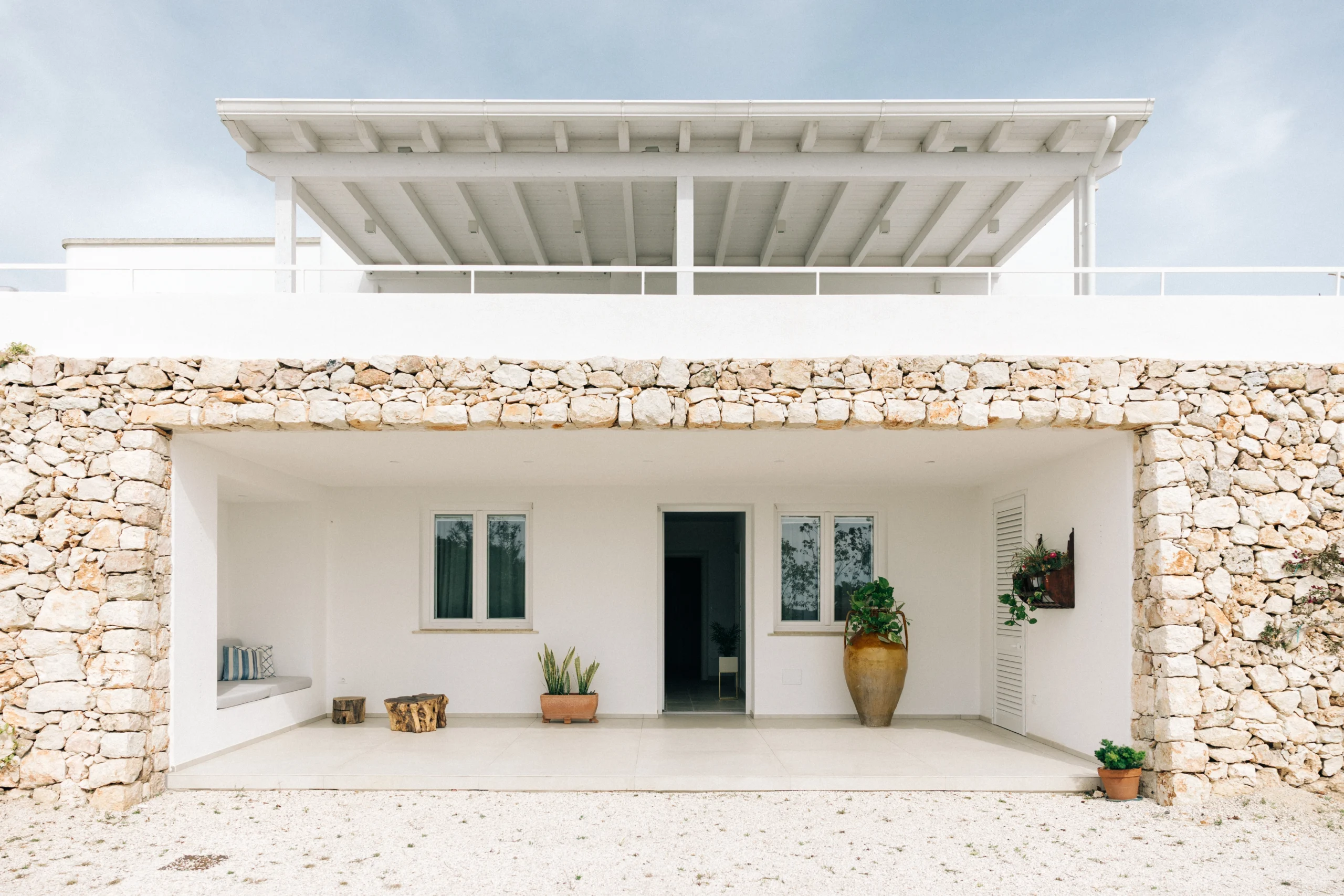 Covered stone patio with outdoor seating and minimalist architecture at luxury villa in Puglia