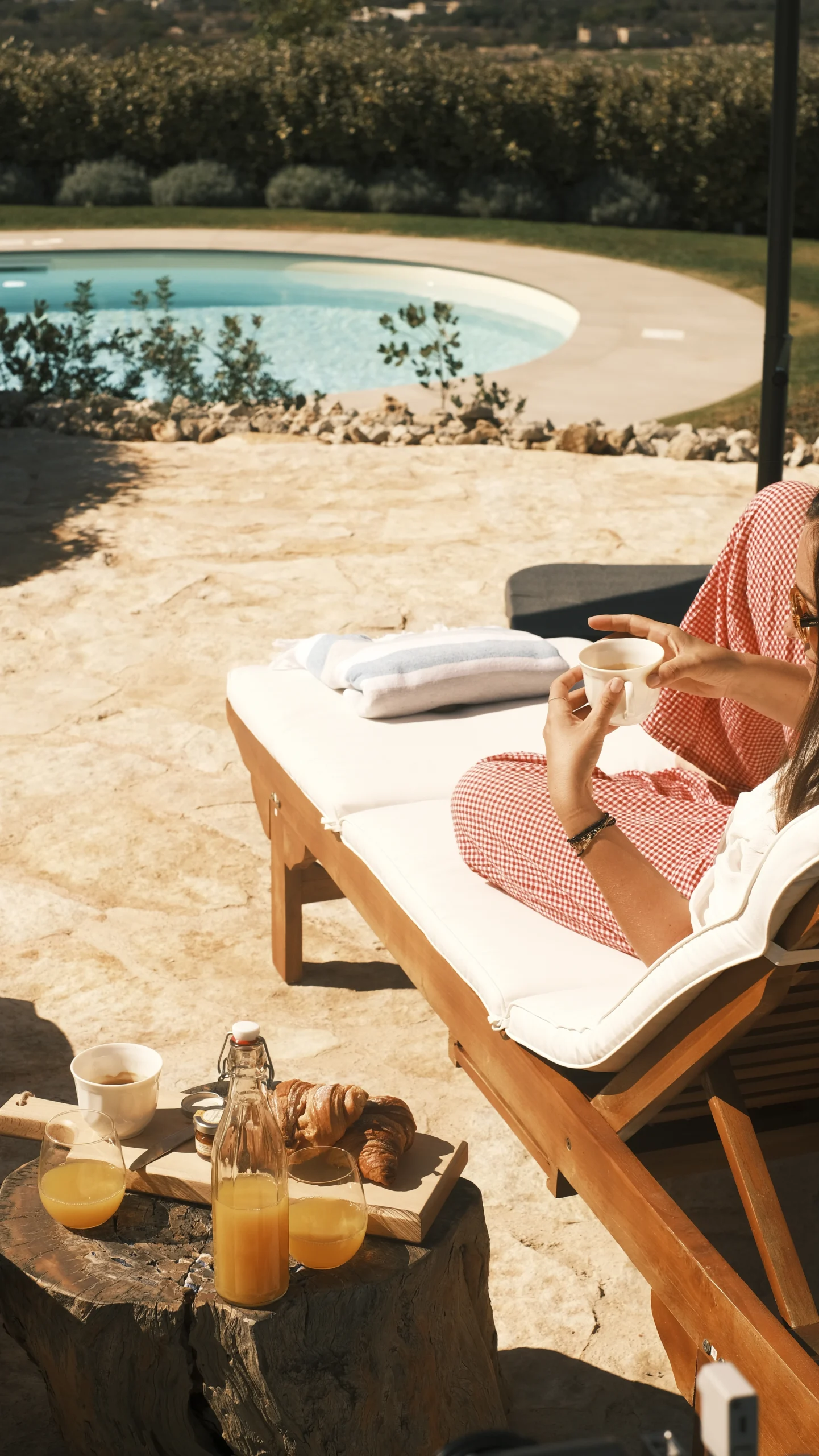 Breakfast served by the pool on wooden sun loungers at luxury countryside villa in Puglia