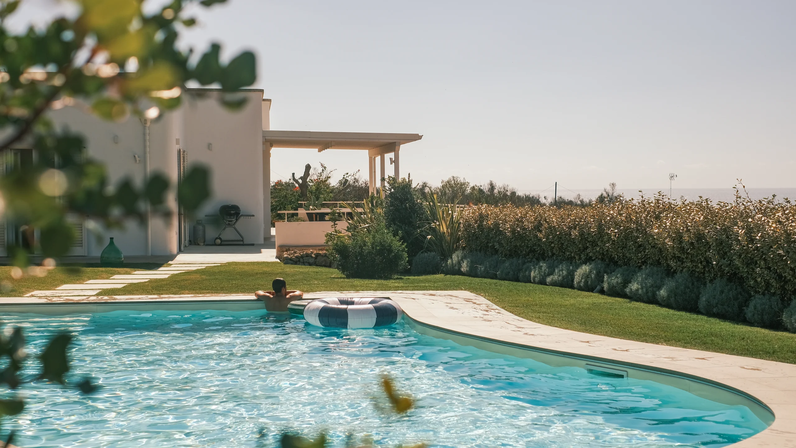 Relaxing poolside moment with sunbathing and garden view at luxury villa in southern Italy