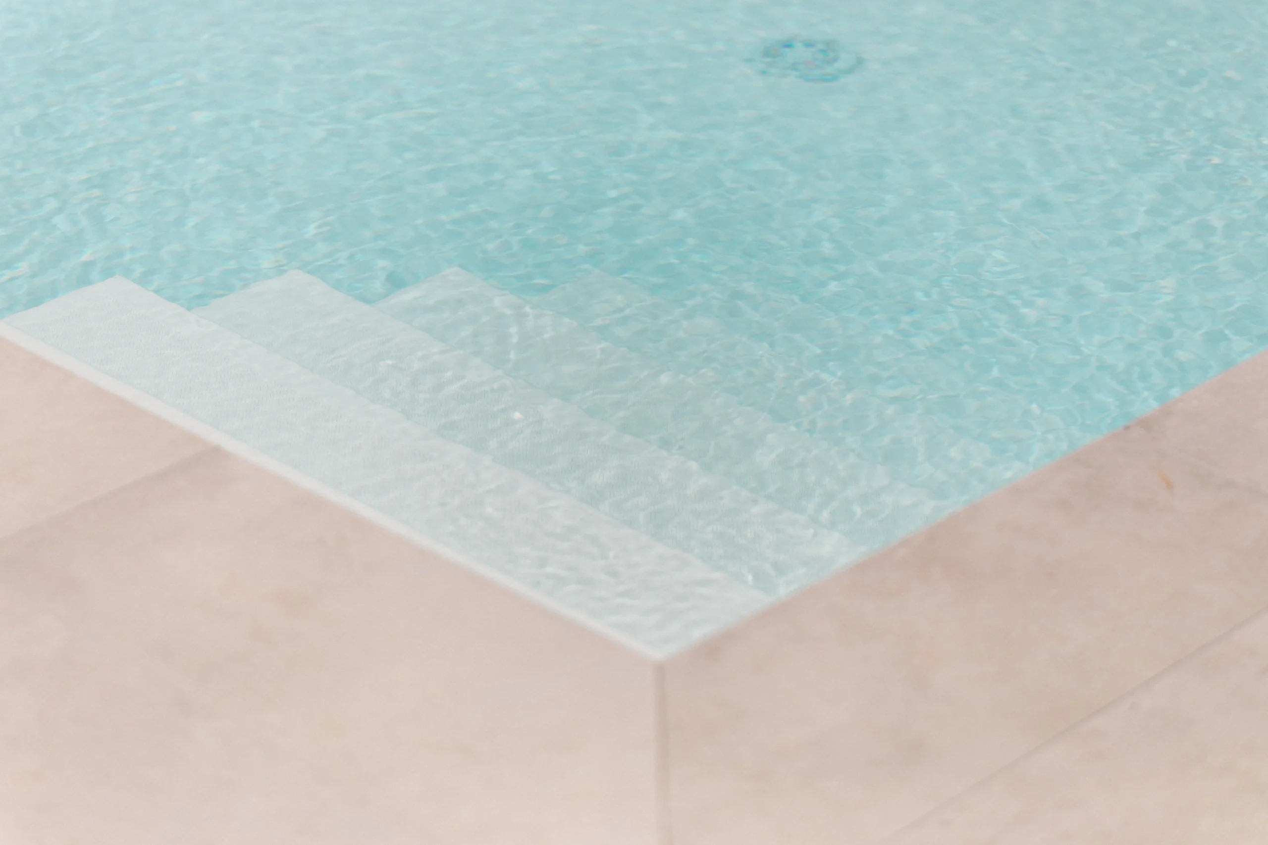 Minimalist pool steps and turquoise water detail at luxury villa in southern Italy