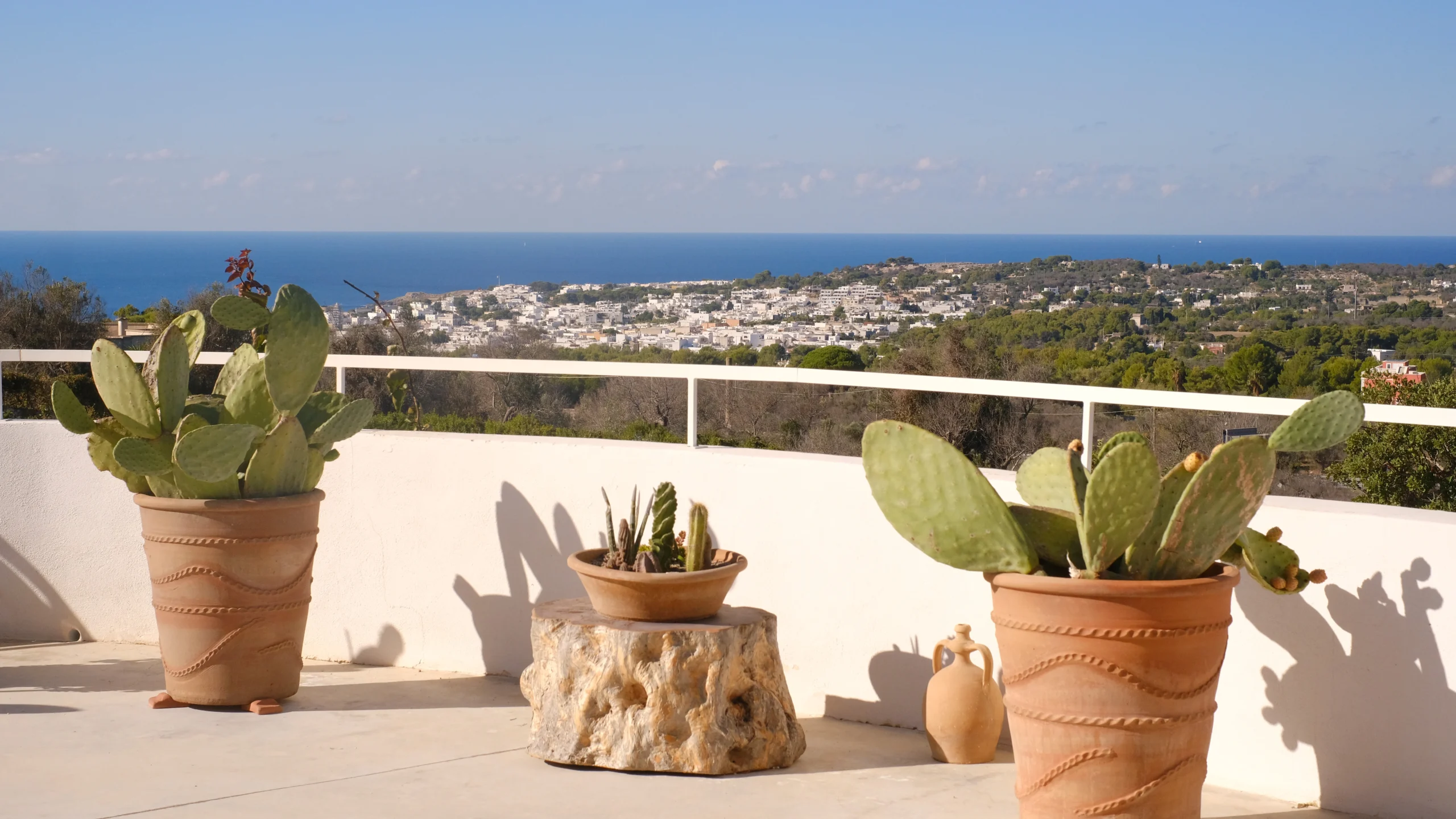 Panoramic terrace view overlooking Mediterranean landscape, village rooftops and the Adriatic Sea in Puglia