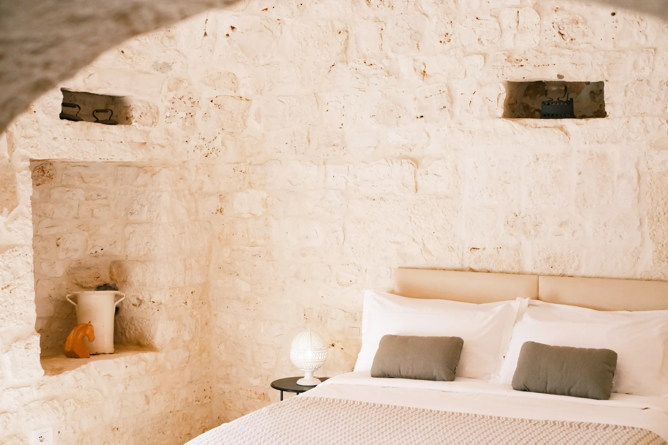 Historic stone bedroom with arched ceiling and minimalist decor at Villa Mira in Puglia