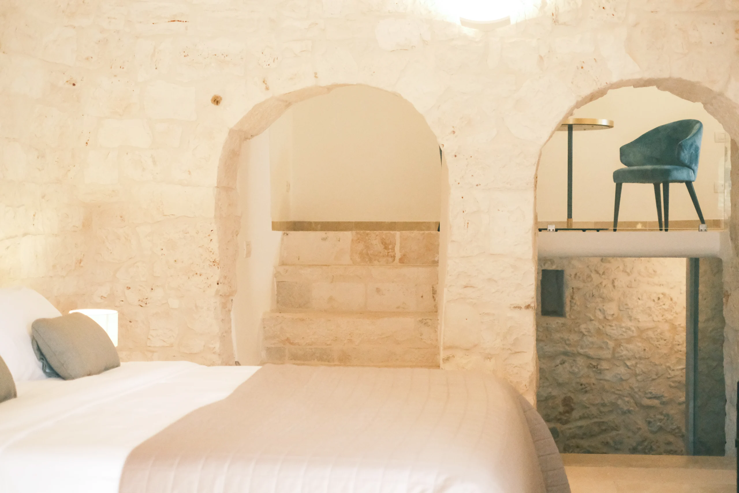 Luxury bedroom carved into stone with arched niches and bespoke lighting in Puglia