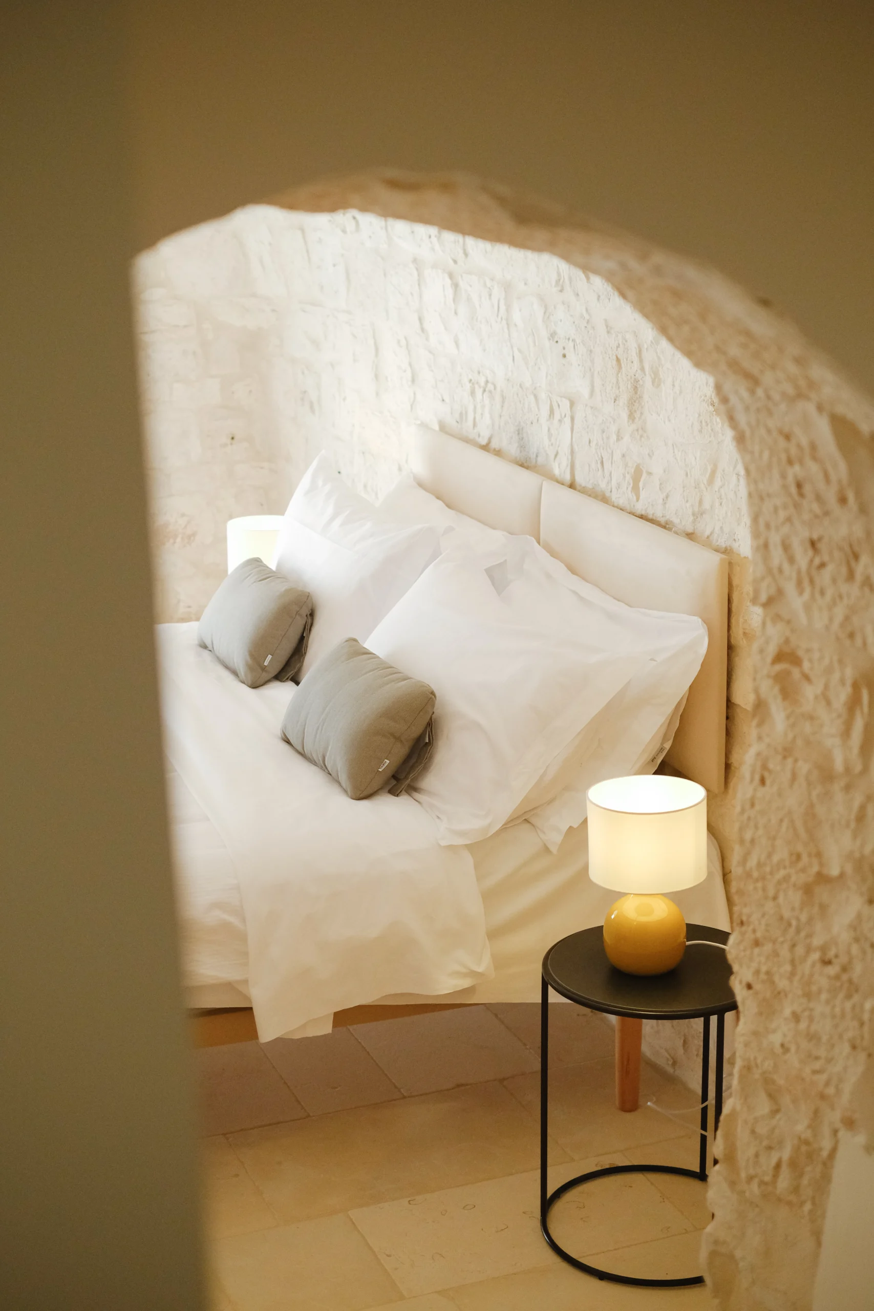 Stone bedroom detail with arched alcove and handcrafted decor in a Puglia luxury villa