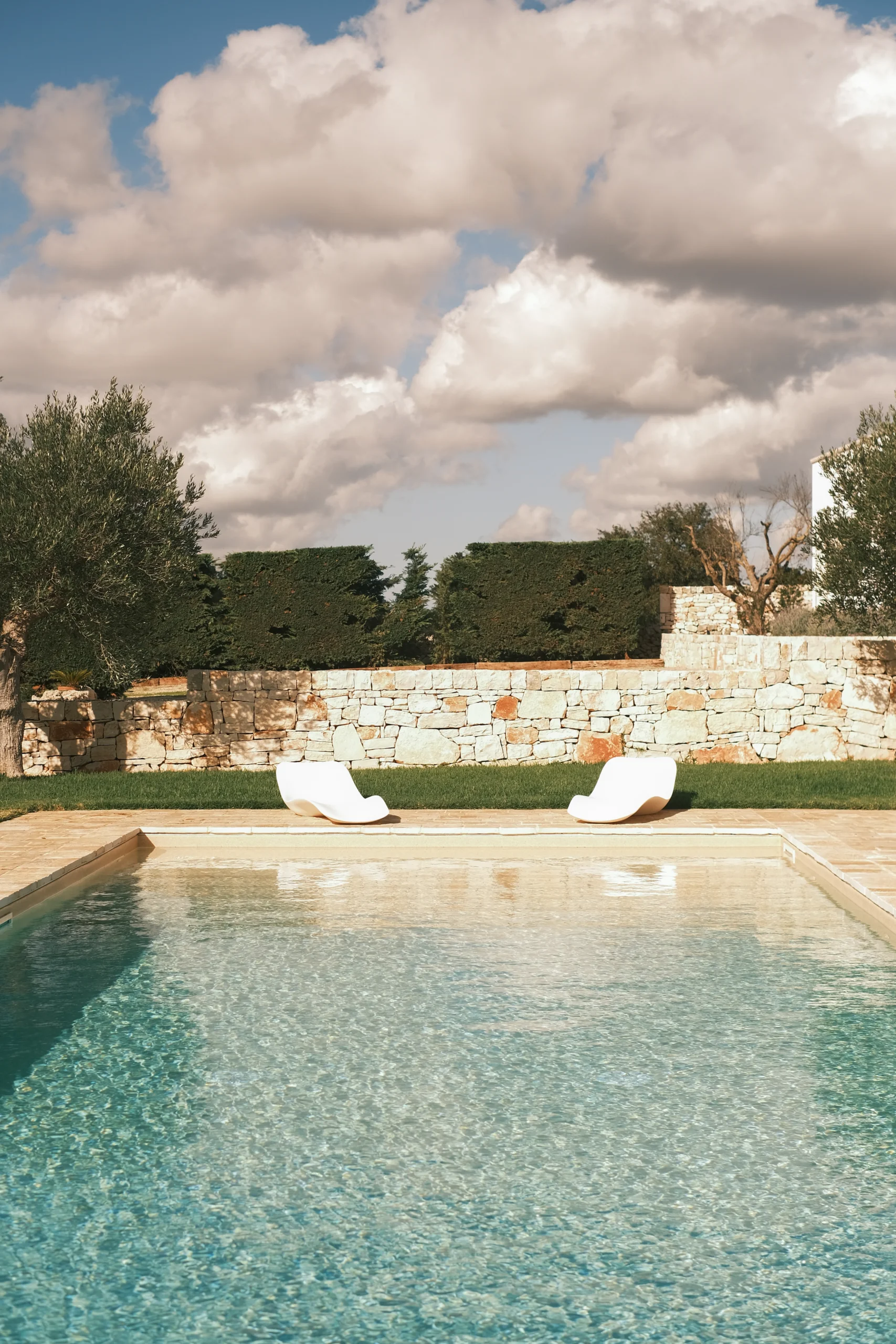 Private swimming pool with stone terrace and olive trees at Villa Mira, luxury villa in Puglia