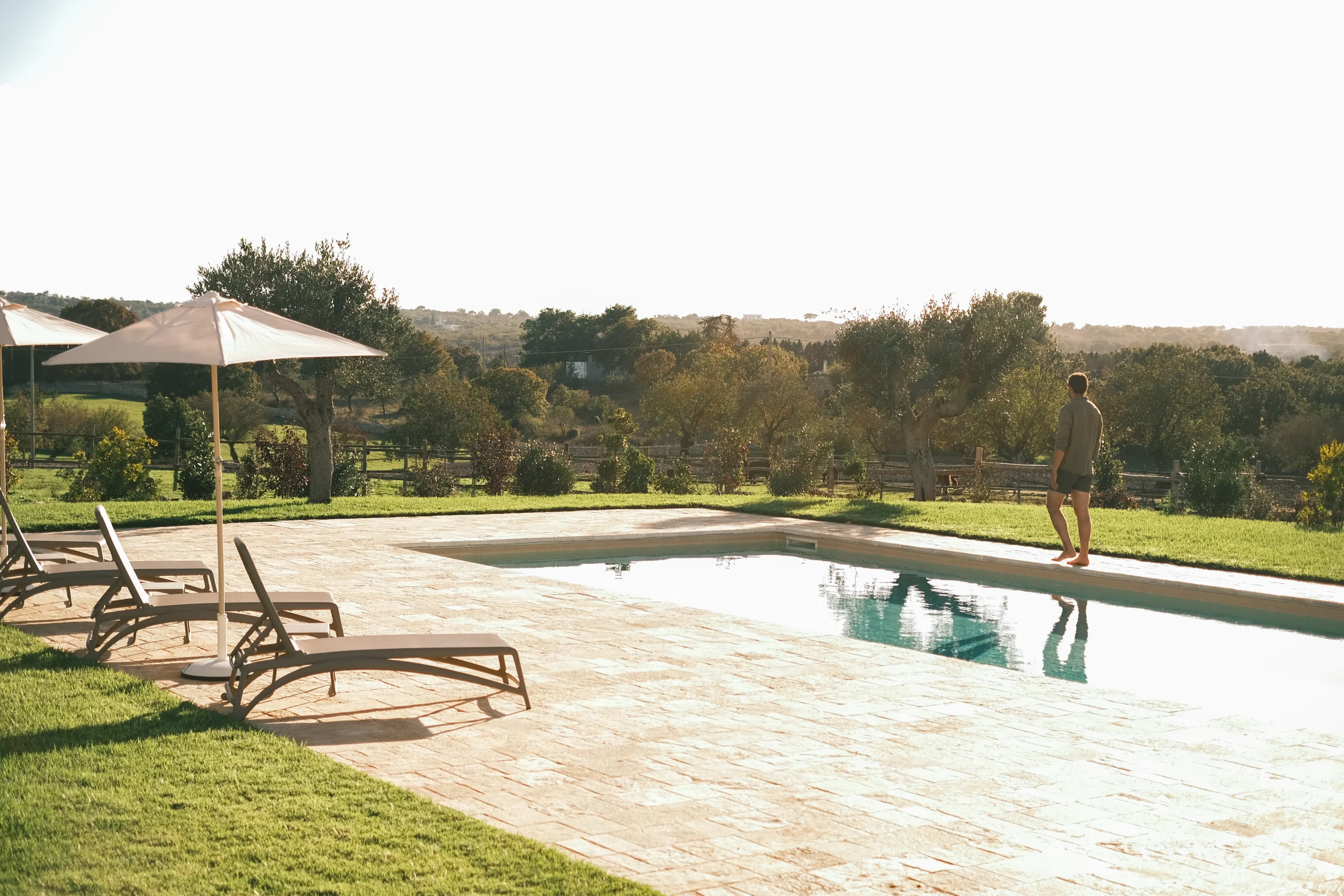 Relaxed poolside lifestyle at a countryside villa in Puglia with olive trees and open views